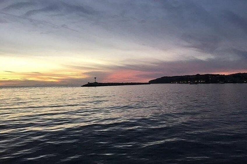 A calm body of water with a distant shoreline and a lighthouse. 4