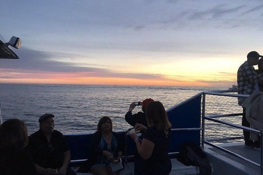 A group of people on a boat during sunset. 4