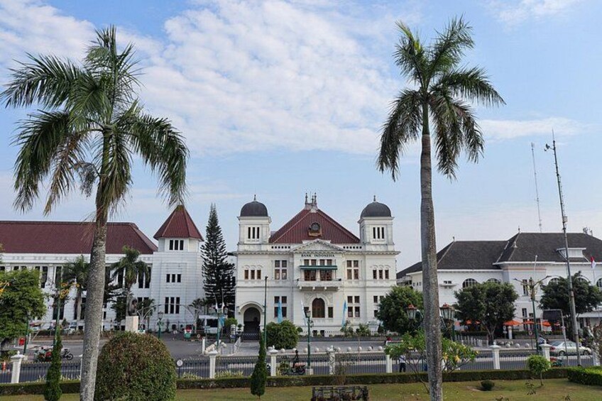 A large white building with a red roof, palm trees, and a clear sky. 2