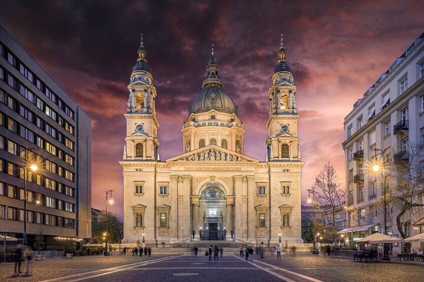 Une cathédrale historique, dotée de deux tours et d’un dôme, entourée de bâtiments modernes et bordée d’une place pavée. 5