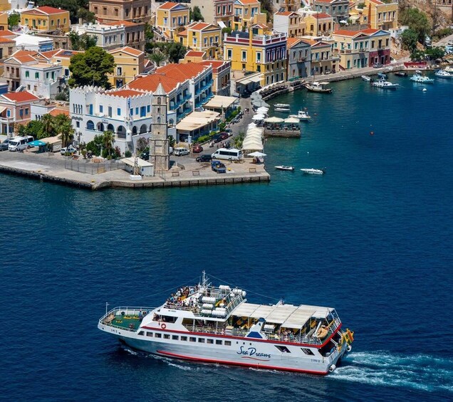A ferry named 'Sea Dreams' traveling through a harbor with colorful buildings and boats. 1
