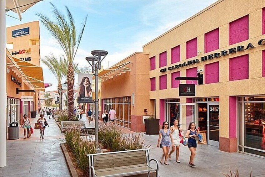 A shopping mall with stores and a bench. 1