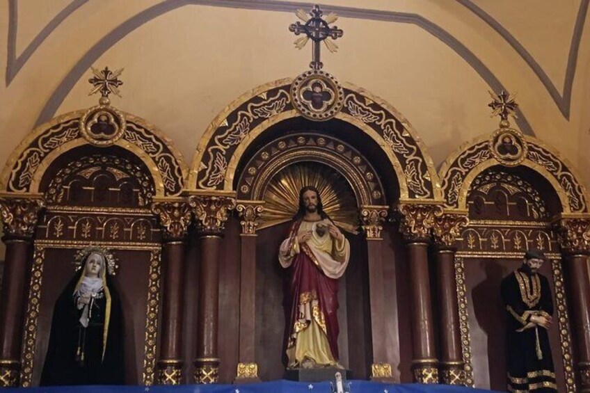 A religious iconostasis with three figures, ornate arches, and a cross. 4