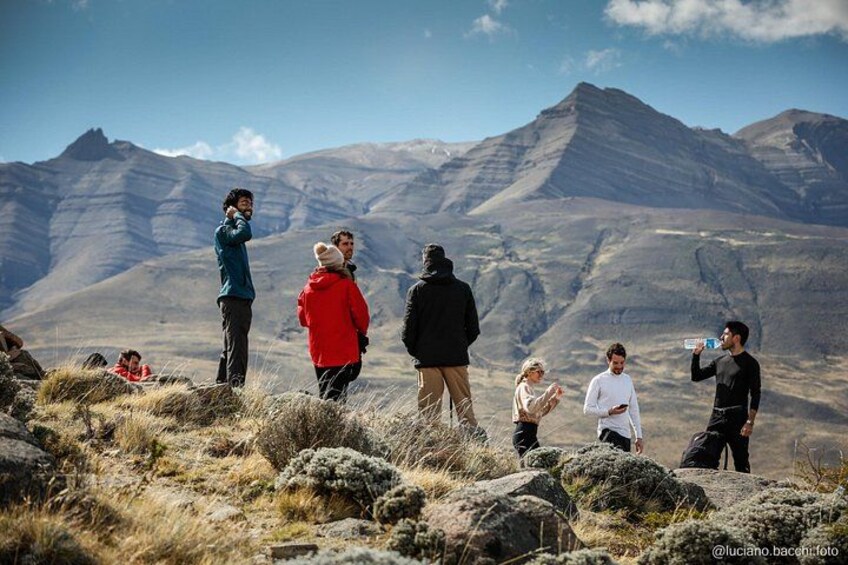A group of people standing on a rocky outcrop with a mountainous landscape in the background. 2