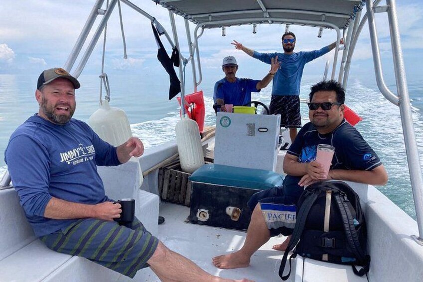 A boat with people on board, a person holding a drink, and a cooler labeled 'PACIFIC'. 2