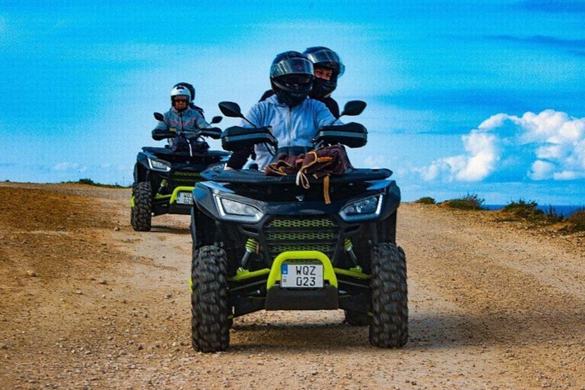 To quad bikes på en grusvej under en klar himmel. 2