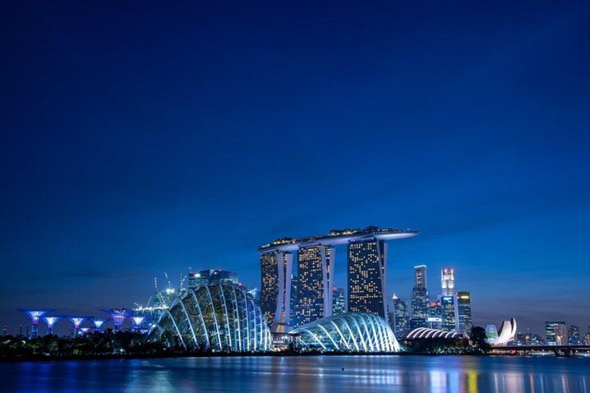 A cityscape at night with illuminated buildings, including a prominent tower with a pointed top. 4