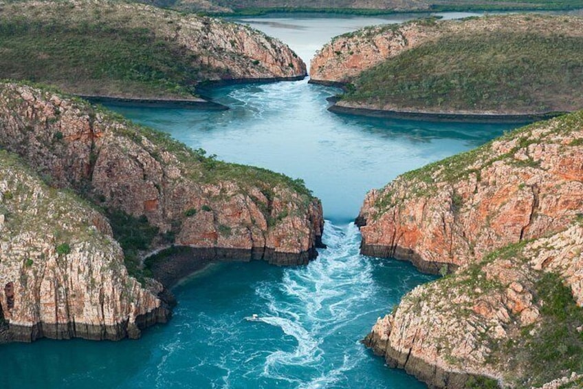 Un río serpentea por un cañón con acantilados rocosos y vegetación escasa. 2