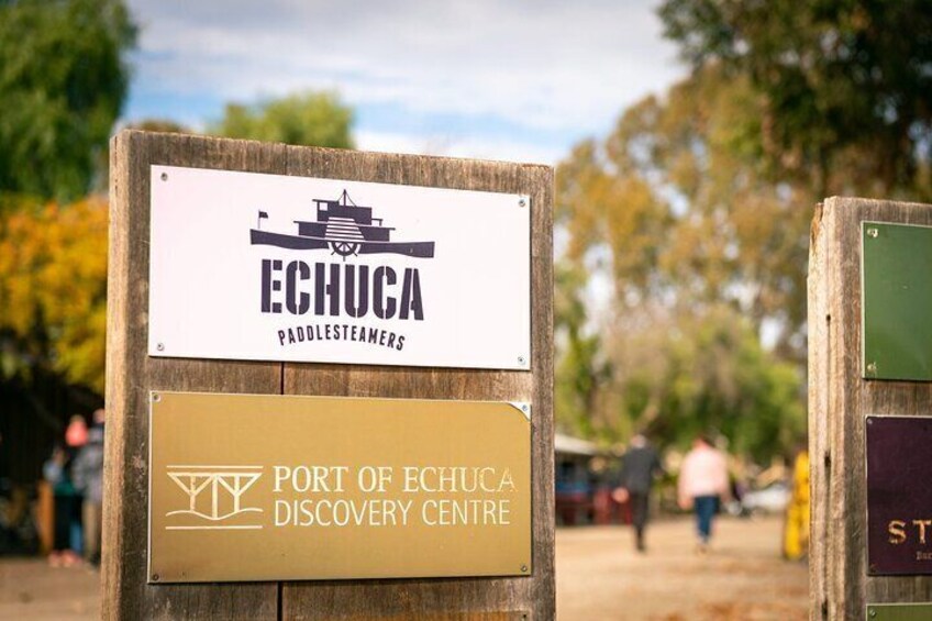 A wooden sign with the Echuca Paddle Steamers logo and the Port of Echuca Discovery Centre name. 5