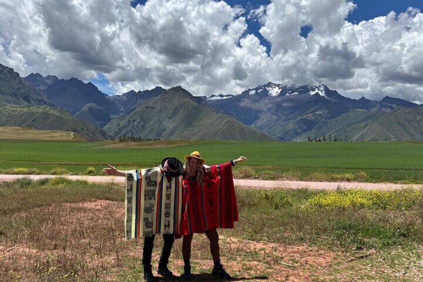Two people standing in a field with mountains in the background. 4