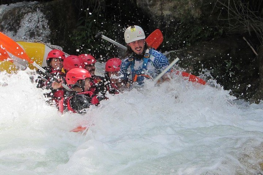 A white water rafting activity with participants wearing helmets and life jackets. 4