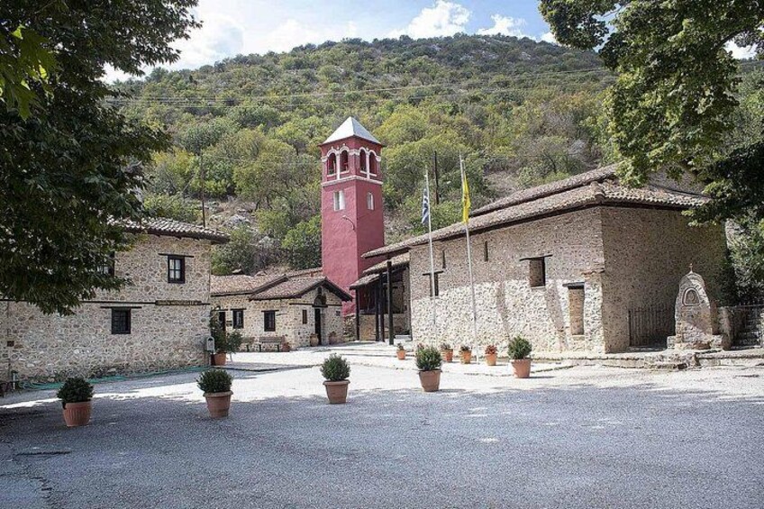 A historic building with a red tower, surrounded by stone walls and potted plants. 2