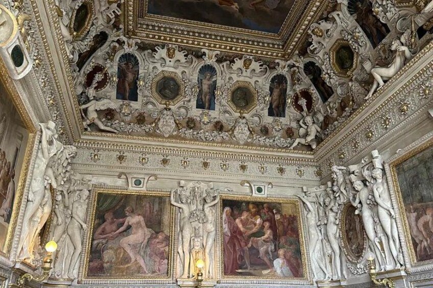 An ornate ceiling with intricate carvings and frescoes. 2