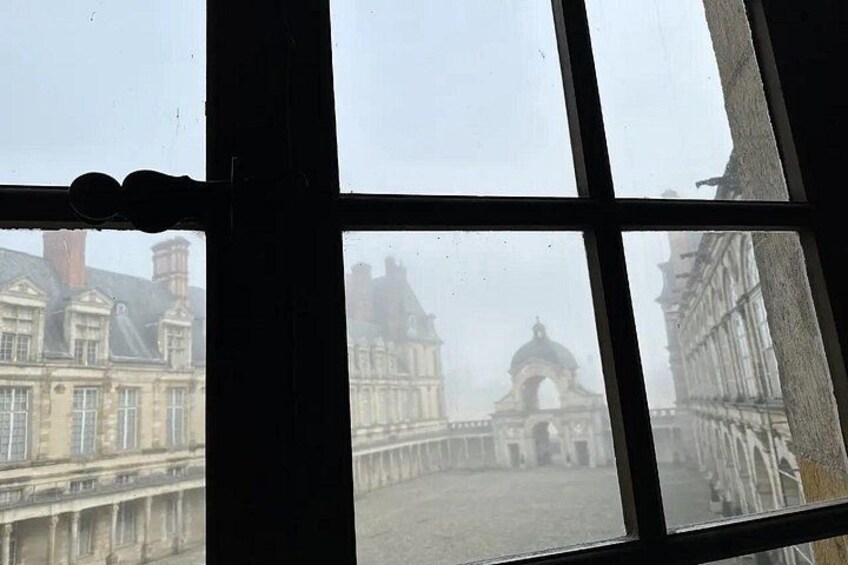 A view through a window of a historic building with a large archway in the background. 5