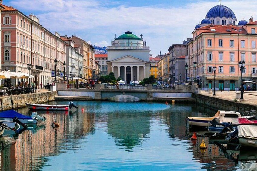A canal with boats, buildings, and a prominent dome structure. 2