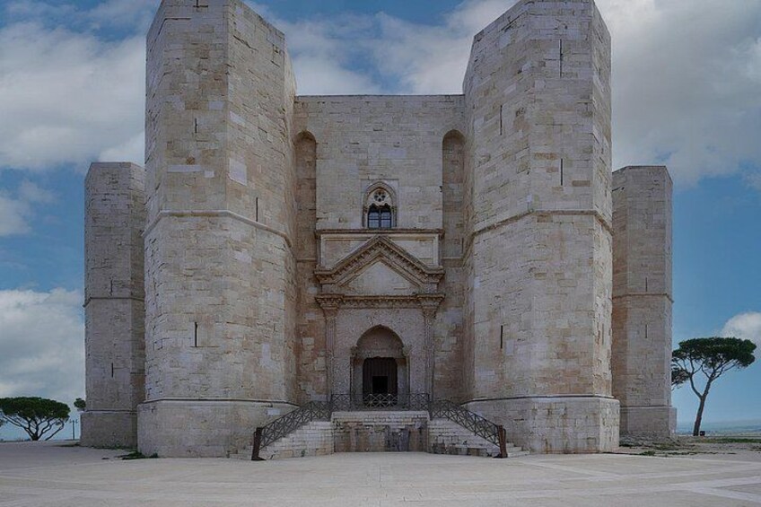 A large stone building with a central entrance, flanked by two tall towers. 5