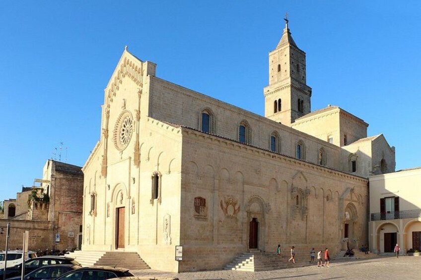 A historic building with a clock tower, arched windows, and a large entrance. 2