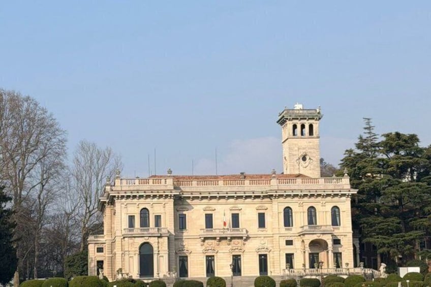 A historic building with a clock tower, arched windows, and a central entrance. 3