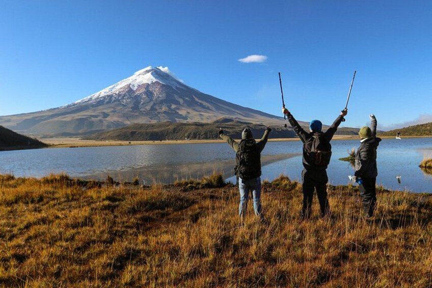 Three people fishing by a lake with a mountain in the background. 1