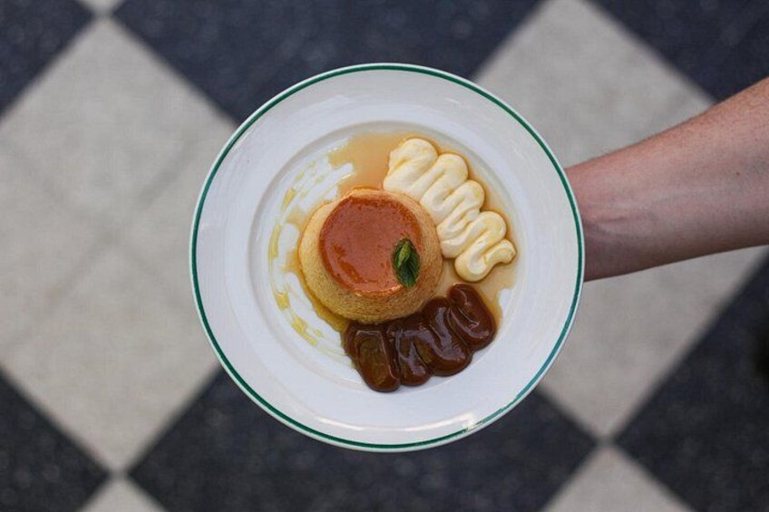 En tallrik med en karamellpudding, karamellsås och vispad grädde. 3