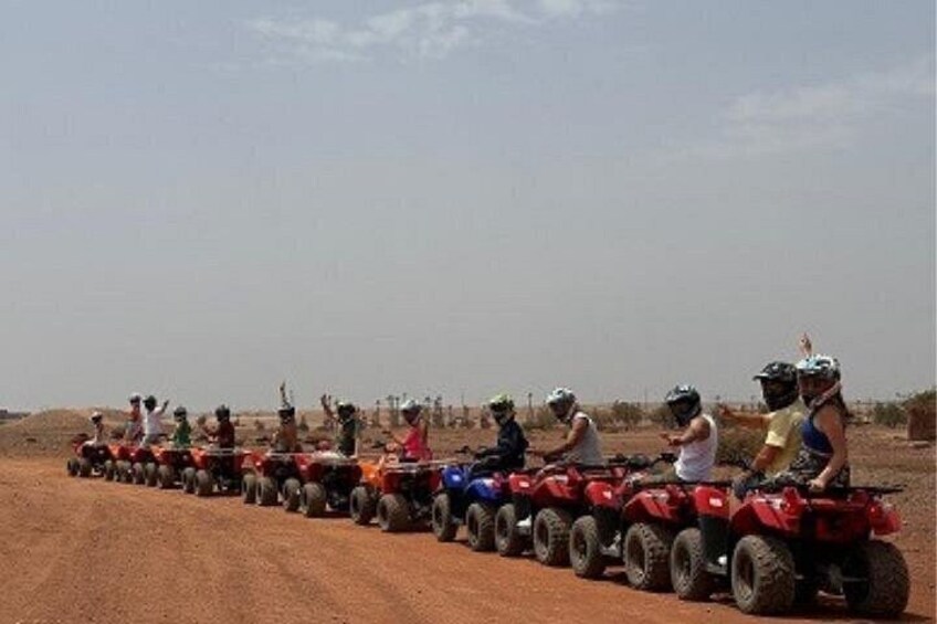 A group of people riding ATVs on a dirt road in a desert landscape. 2