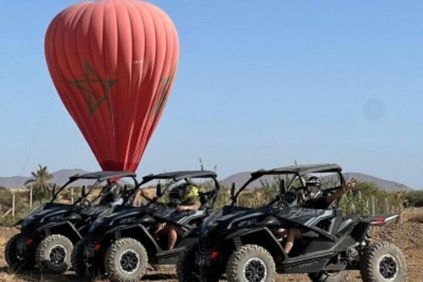 Two off-road vehicles with a red hot air balloon in the background. 5