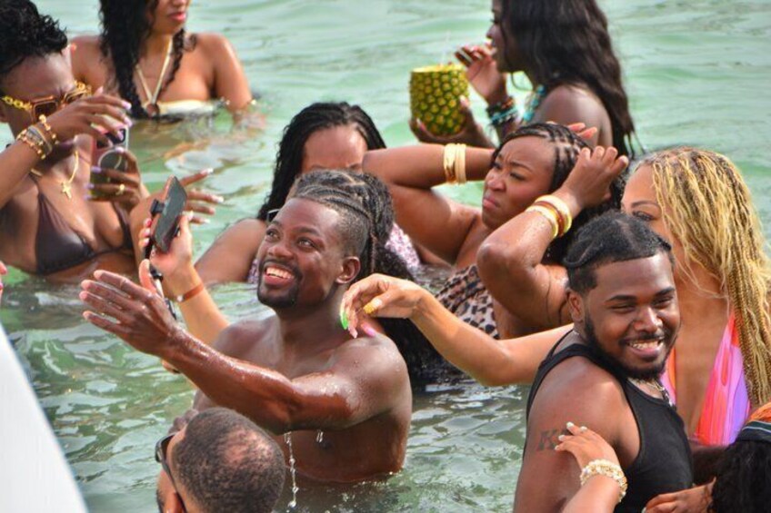 People in a body of water, some holding phones. 2
