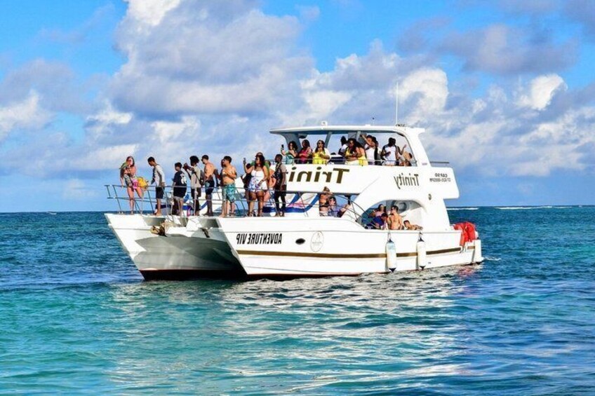 A white boat with 'Yacht' written on the side, people on board, and calm blue sea. 1