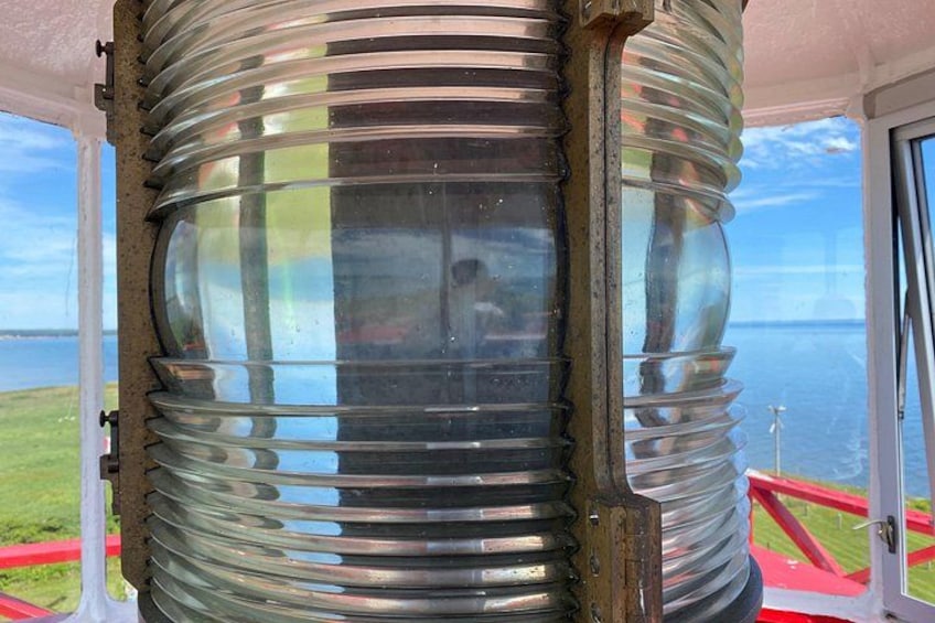 En cylindrisk glasstruktur med vandrette riller, en metalbase og en reflekterende overflade. 5