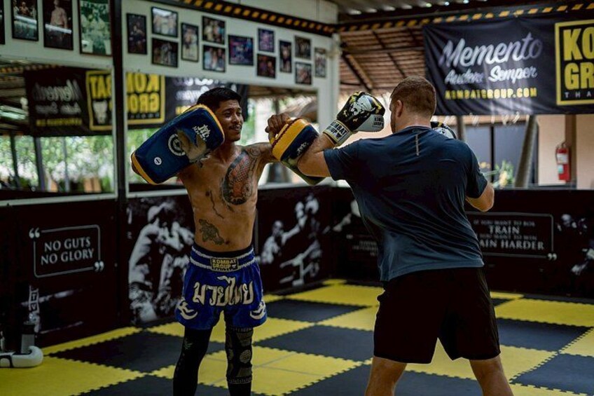 A boxing training session with a punching bag and motivational posters in the background. 4