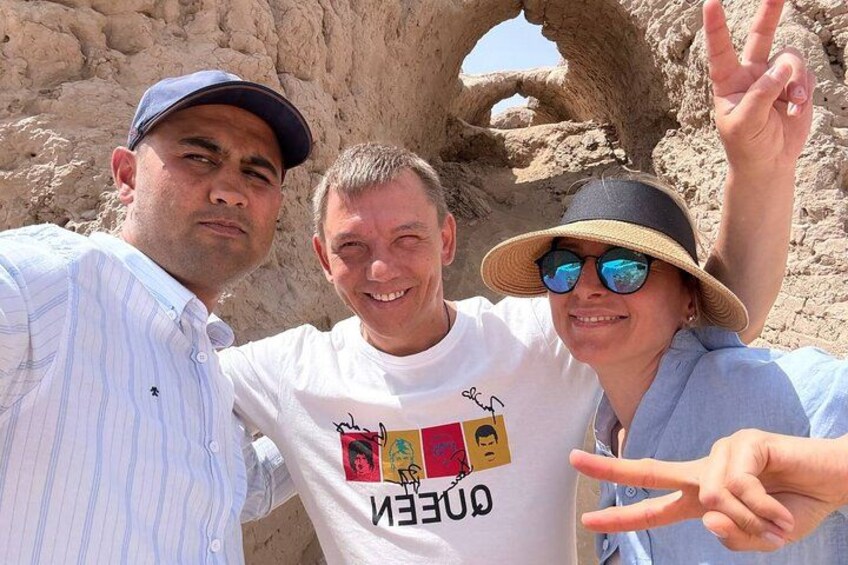 Three people posing in front of a rock formation. 2