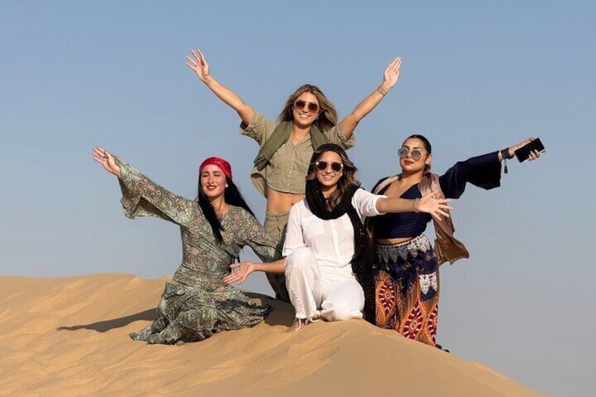 A group of people on a sand dune with a clear sky. 4