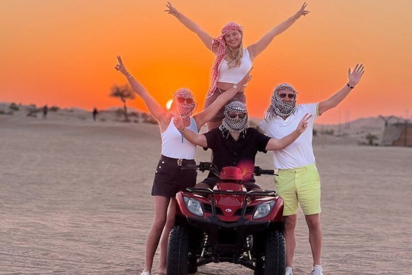 A group of people on a dune with a sunset in the background. 2