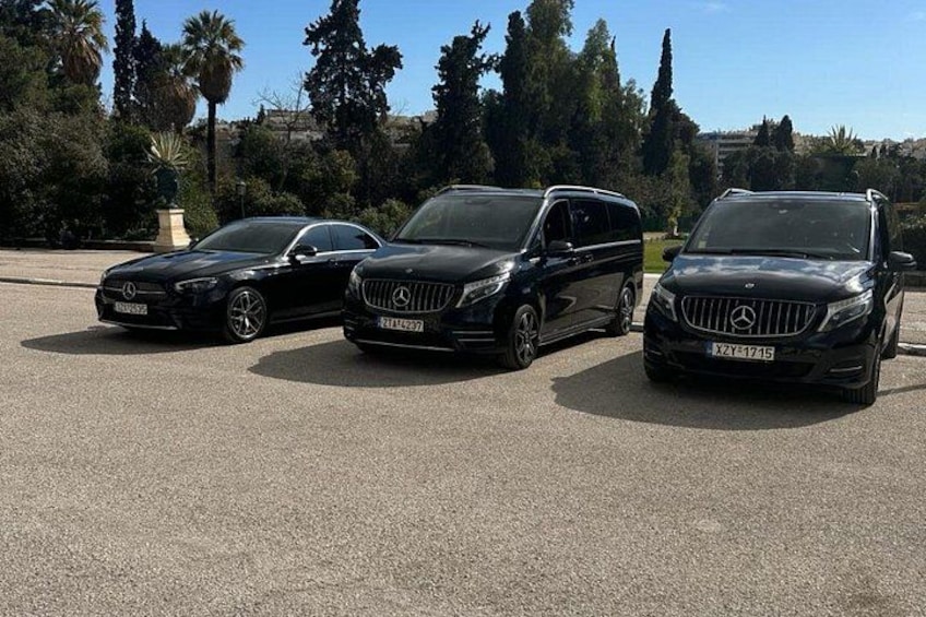 Tres vehículos negros Mercedes-Benz estacionados en un estacionamiento con árboles y cielo despejado al fondo. 5