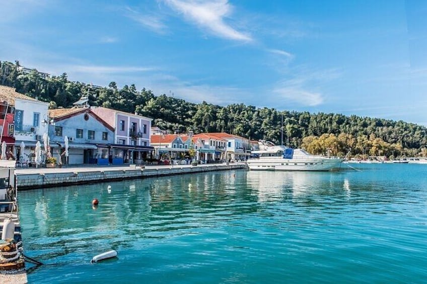 A waterfront town with buildings, a boat, and calm water. 2