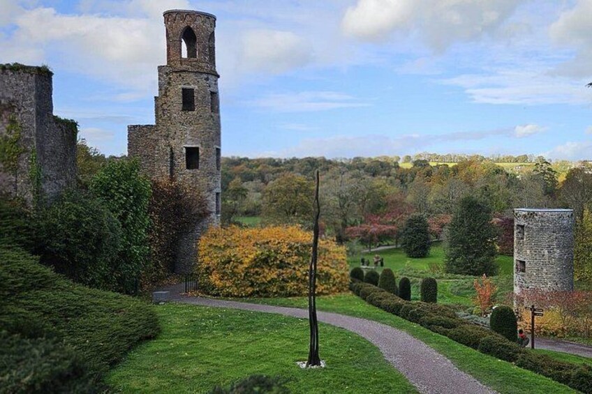 A historic stone tower, a well-maintained hedge, and a clear sky. 2