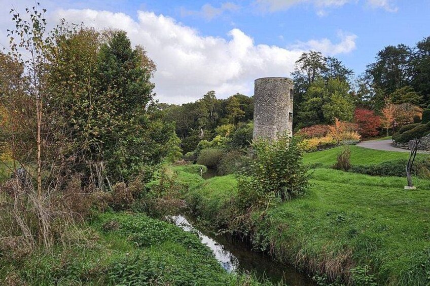 A stone tower, a stream, and lush greenery. 3