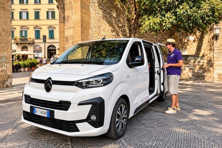 A white van parked on a cobblestone street with a man standing beside it. 2