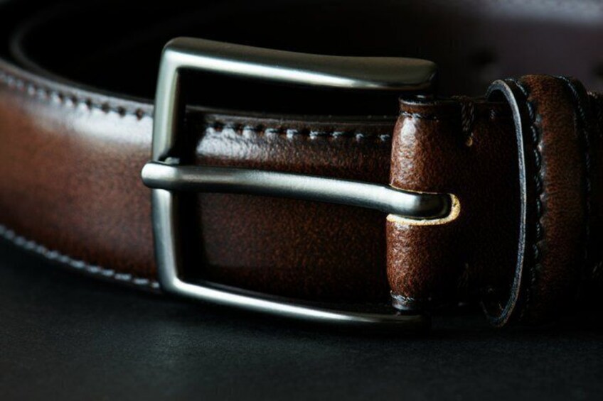 A close-up of a brown leather belt with a silver buckle. 5