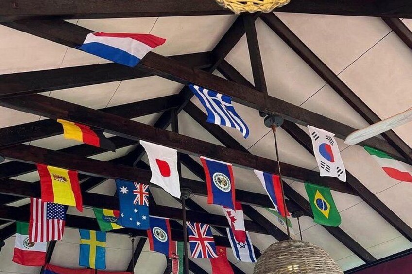 Eine Decke mit Holzbalken und verschiedenen Nationalflaggen, die daran hängen. 4
