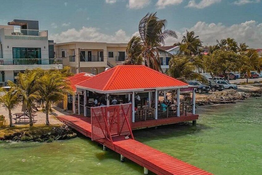 Ein Restaurant am Wasser mit rotem Dach und einer Anlegestelle, die ins Wasser ragt. 2