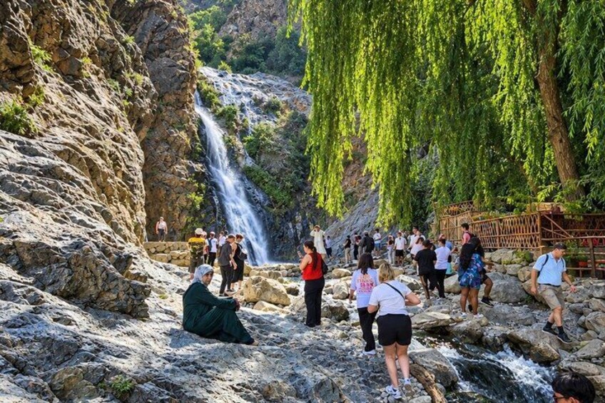 Une cascade, un paysage rocheux et des personnes qui contemplent la nature. 1