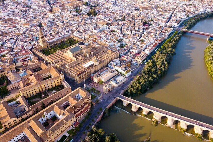 An aerial view of a city with a river, a bridge, and historic buildings. 5