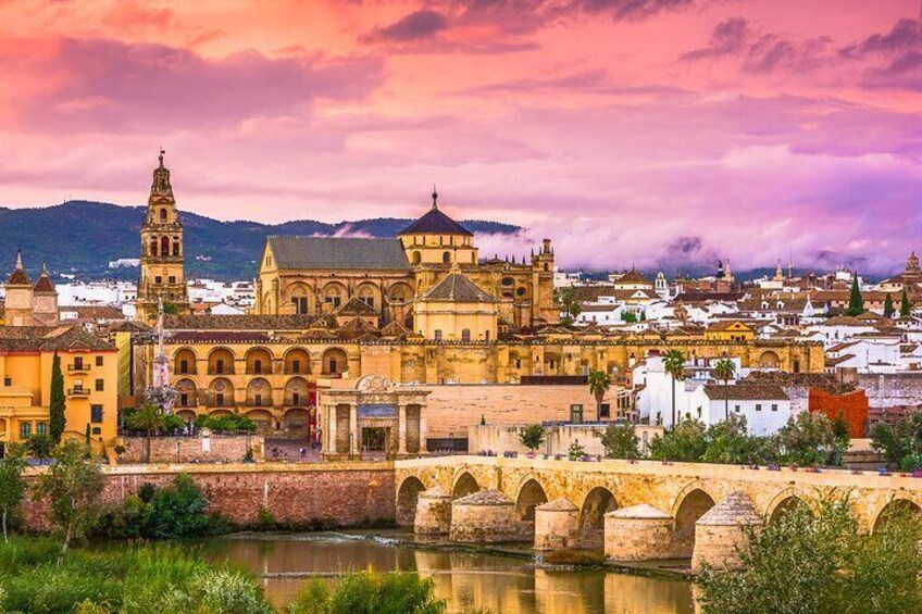 A historic cityscape with a prominent cathedral, a bridge, and a river. 1