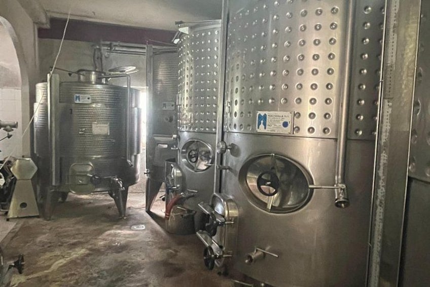 Stainless steel industrial equipment, including tanks and pipes, in a warehouse setting. 4