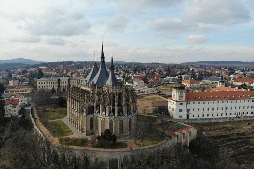Una catedral histórica con una aguja distintiva, rodeada de un paisaje urbano con diversos edificios y una vista distante de colinas. 3