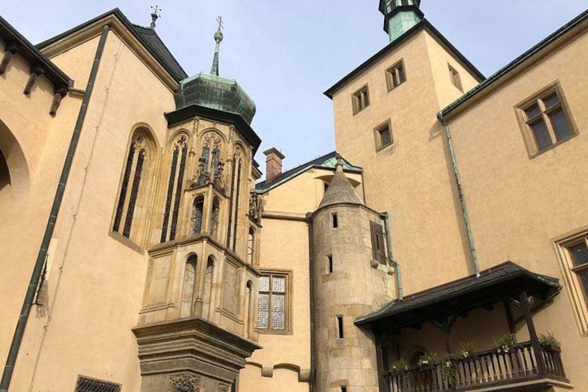 Un edificio histórico con una torre de campanas, ventanas arqueadas y una torreón. 2