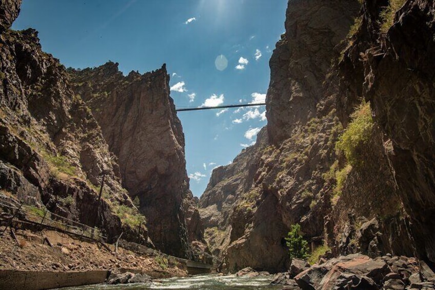 Un canyon con un fiume, pareti rocciose e un ponte sospeso. 5