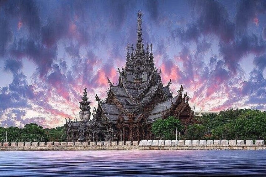 A traditional temple with multiple tiers and a spire, surrounded by water and greenery. 1