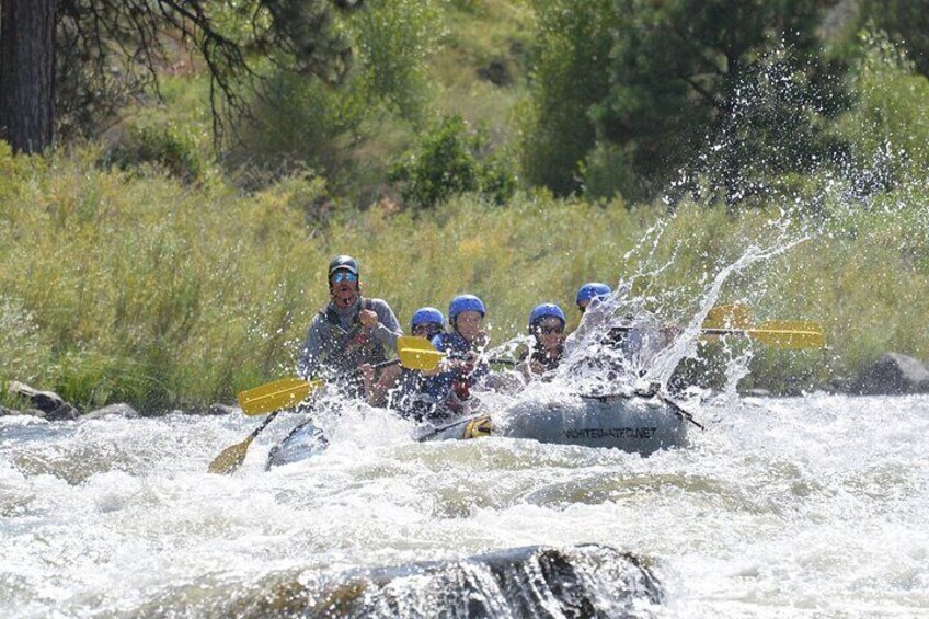 A group of people in a raft navigating a river. 5